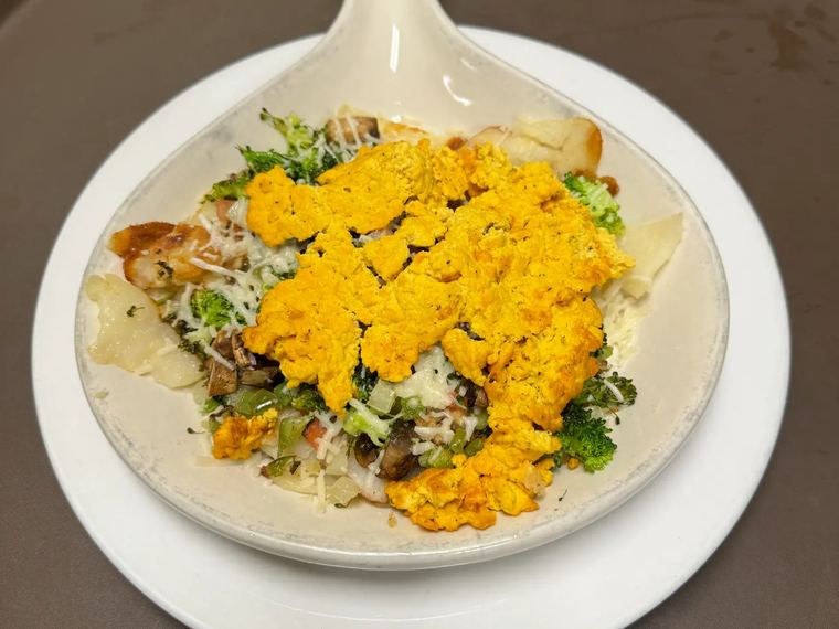 A vegan skillet with tofu scramble, vegetables and American fries.